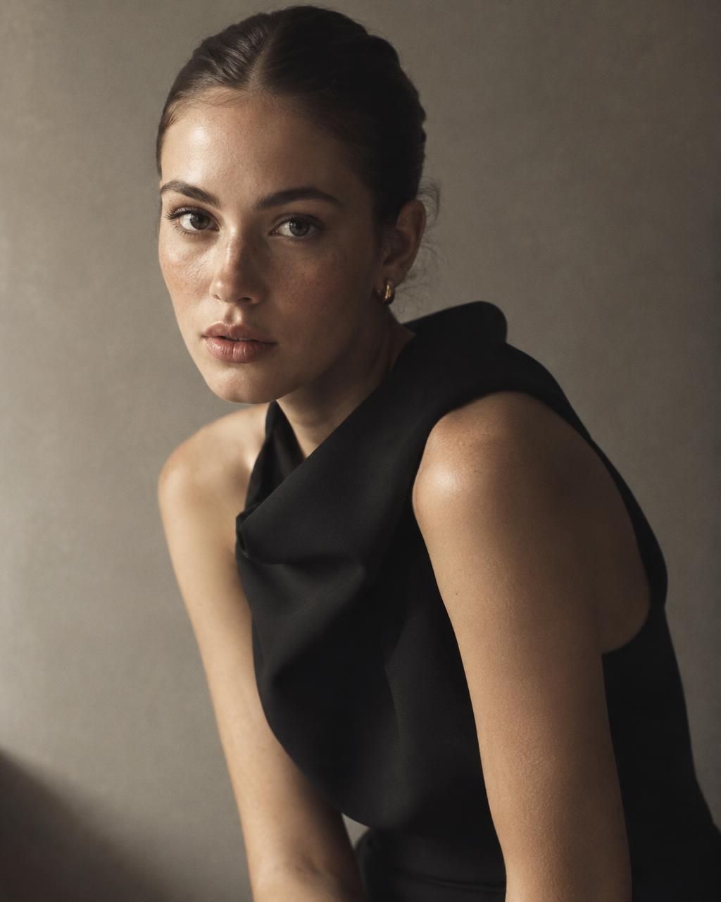 Editorial portrait of a woman in a sculptural black dress